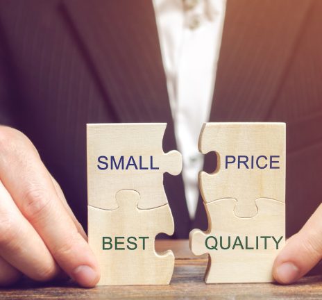 A businessman collects wooden puzzles with the words Small price - best quality