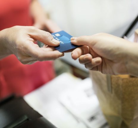 Pocus Locus Close-up of customer giving credit card to sales clerk